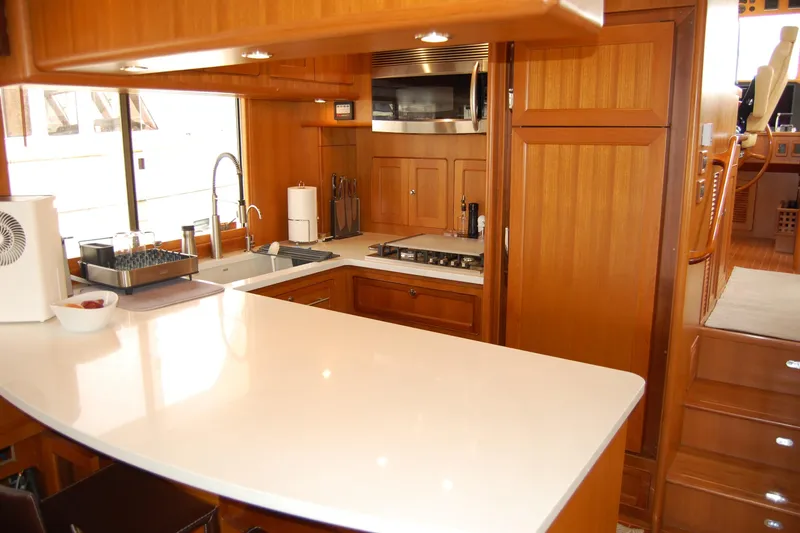 Blue Red Yacht Photos Pics Luxurious 2006 Selene Pilothouse Ocean Trawler kitchen with modern appliances and wooden cabinetry.