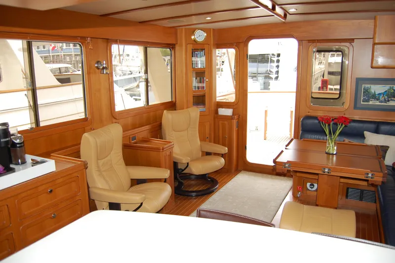 Blue Red Yacht Photos Pics Luxurious 2006 Selene Pilothouse Ocean Trawler interior with leather chairs and wooden furnishings.