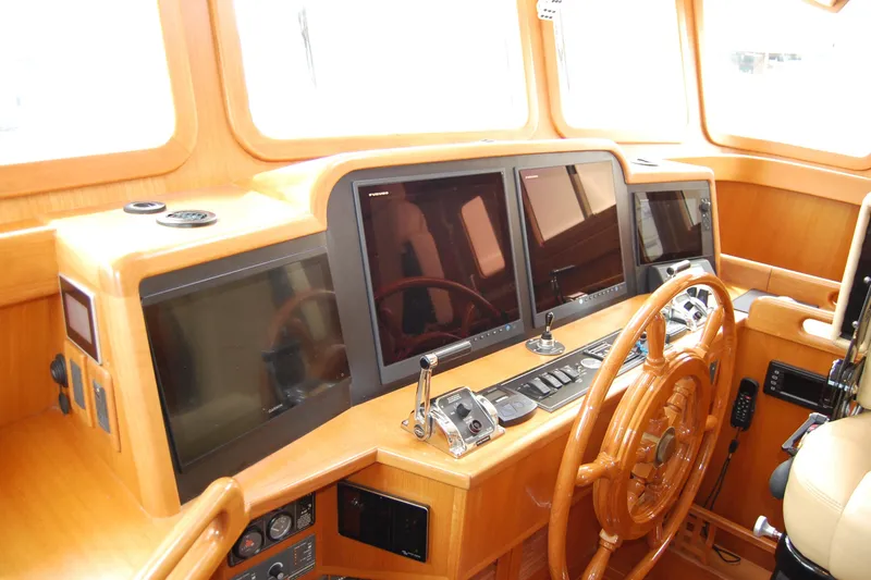 Blue Red Yacht Photos Pics Pilothouse of 2006 Selene Ocean Trawler with wooden steering wheel and modern navigation screens.