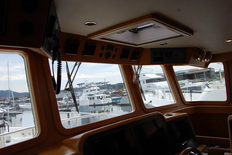 Blue Red Yacht Photos Pics Pilothouse interior of 2006 Selene Pilothouse Ocean Trawler, overlooking marina with yachts.