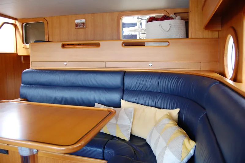 Blue Red Yacht Photos Pics Interior of 2006 Selene Pilothouse Ocean Trawler with blue leather seating and wooden table.