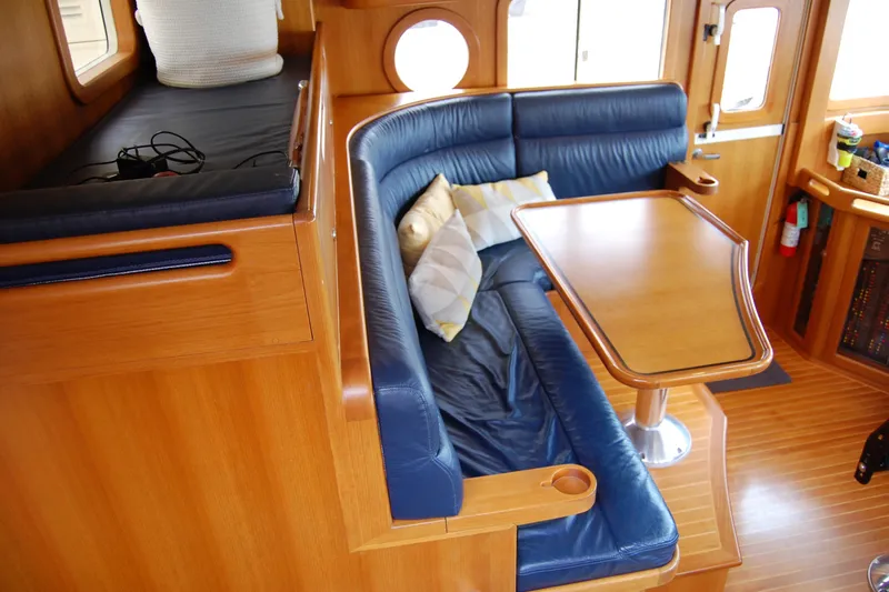 Blue Red Yacht Photos Pics Interior of 2006 Selene Pilothouse Ocean Trawler with blue leather seating and wooden table.