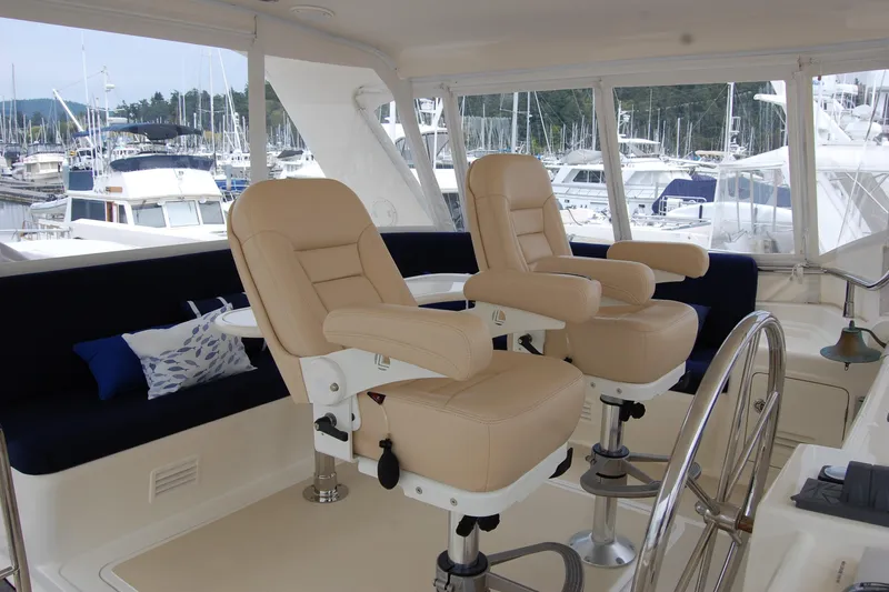 Blue Red Yacht Photos Pics Pilothouse of 2006 Selene Ocean Trawler with beige captain chairs and marina view.