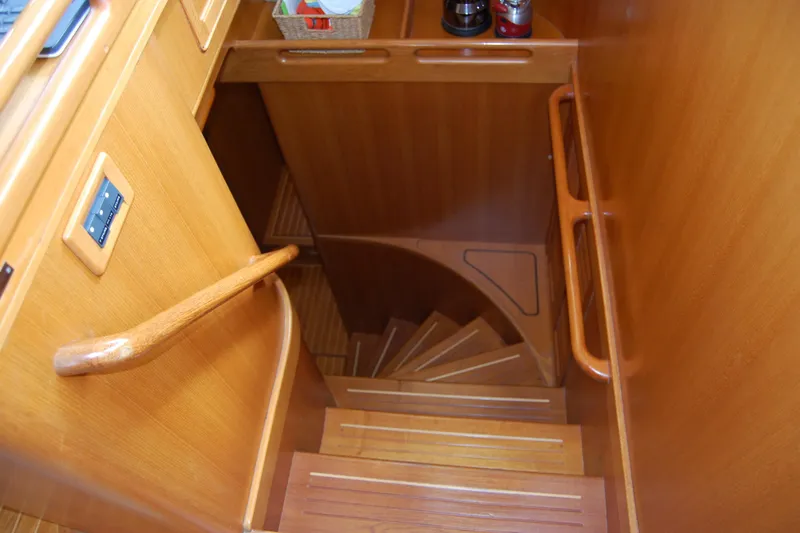 Blue Red Yacht Photos Pics Wooden staircase inside 2006 Selene Pilothouse Ocean Trawler yacht, featuring elegant design and craftsmanship.