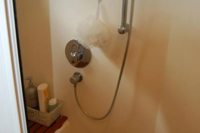 Blue Red Yacht Photos Pics Shower area in 2006 Selene Pilothouse Ocean Trawler with toiletries and handheld showerhead.