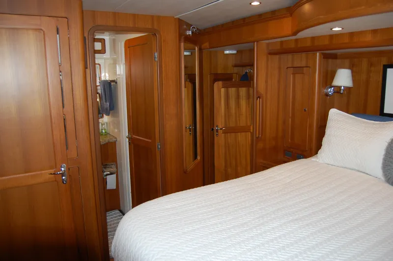 Blue Red Yacht Photos Pics Luxurious 2006 Selene Pilothouse Ocean Trawler cabin with wooden interior and cozy bedding.