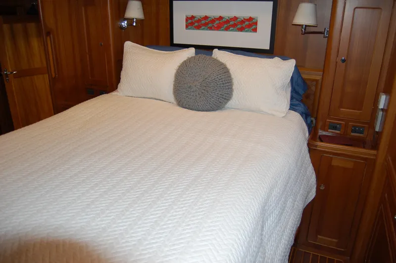 Blue Red Yacht Photos Pics Cozy bedroom in 2006 Selene Pilothouse Ocean Trawler with wood paneling and white bedding.
