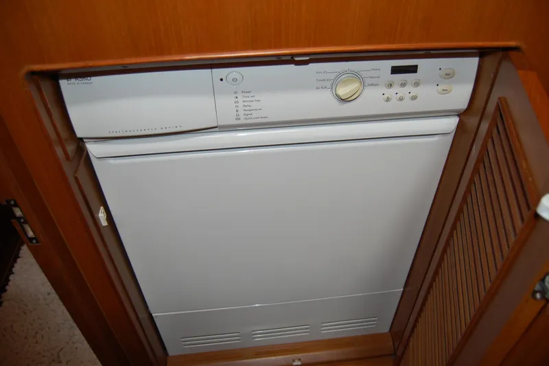 Blue Red Yacht Photos Pics Built-in dryer in 2006 Selene Pilothouse Ocean Trawler, featuring control panel and wooden cabinetry.