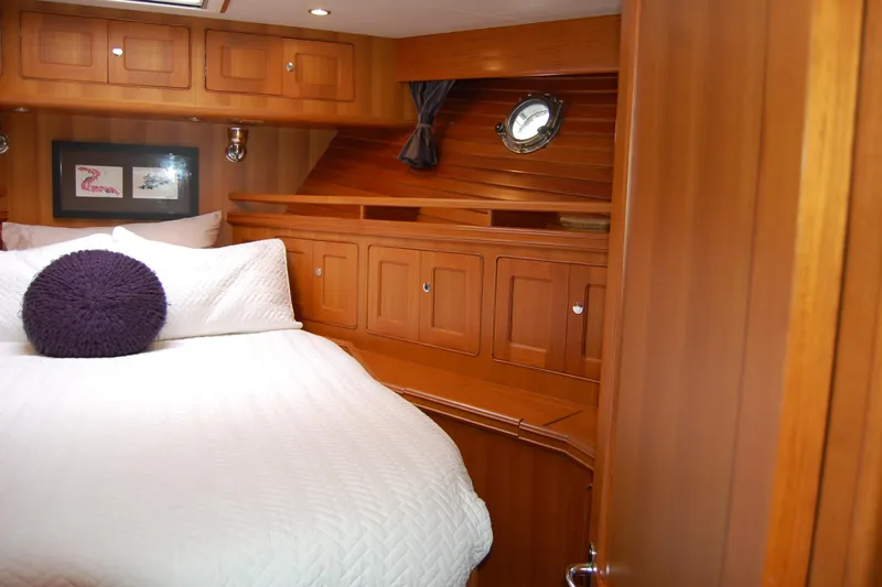 Blue Red Yacht Photos Pics Luxurious 2006 Selene Pilothouse Ocean Trawler cabin with wood paneling and cozy bedding.