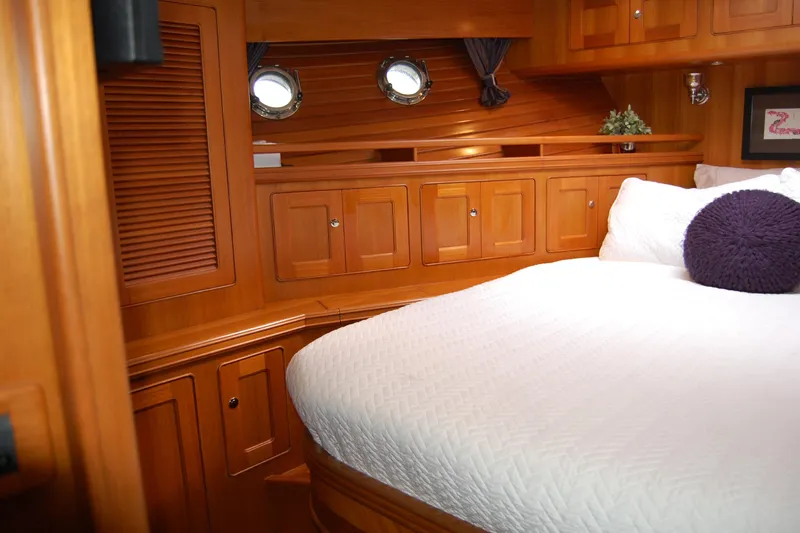 Blue Red Yacht Photos Pics Luxurious 2006 Selene Pilothouse Ocean Trawler cabin with wood paneling and cozy bedding.