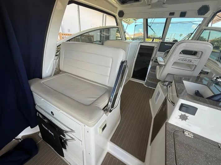  Yacht Photos Pics 2016 Boston Whaler 345 Conquest interior with seating and helm, showcasing luxury and functionality.