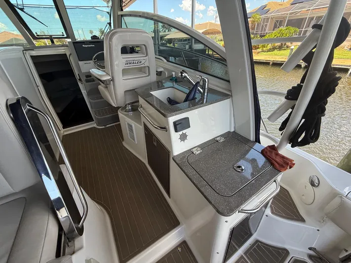  Yacht Photos Pics 2016 Boston Whaler 345 Conquest interior with helm, sink, and seating area.