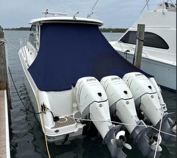  Yacht Photos Pics 2016 Boston Whaler 345 Conquest with triple outboard engines docked, covered with a blue tarp.