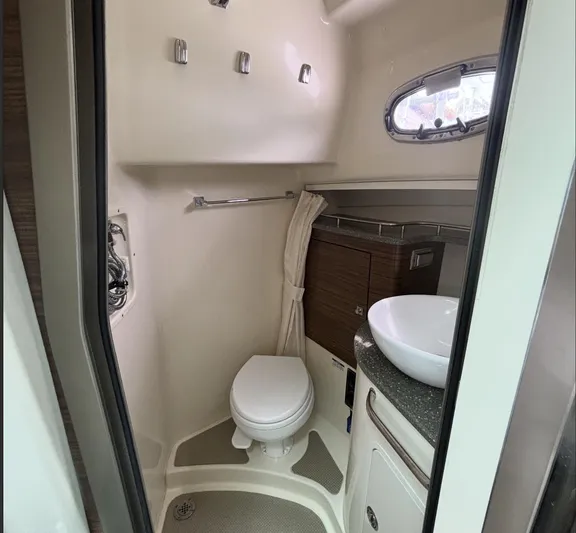  Yacht Photos Pics 2016 Boston Whaler 345 Conquest bathroom interior with toilet, sink, and porthole window.