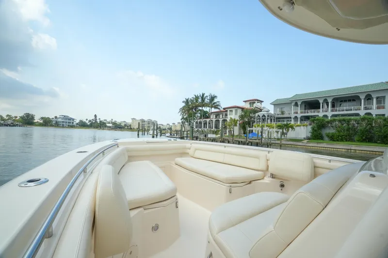  Yacht Photos Pics 2019 Grady-White Canyon 336 boat with luxurious seating, cruising near waterfront homes.
