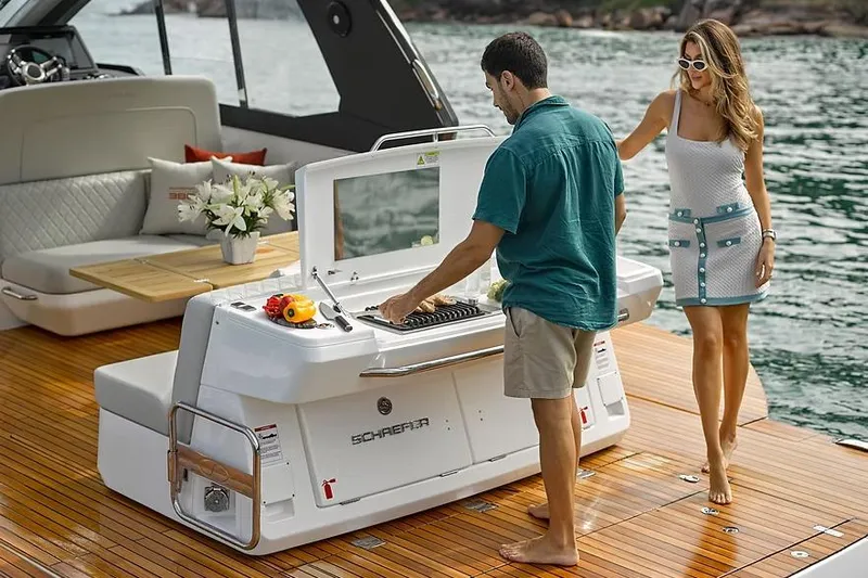  Yacht Photos Pics Manufacturer Provided Image: Couple enjoying barbecue on Schaefer 380 yacht, 2025 model, with elegant deck and seating.