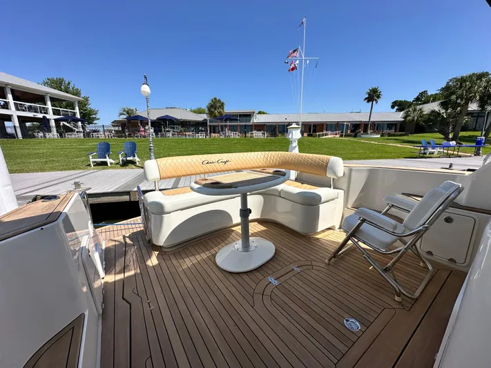 Hula Girl Yacht Photos Pics Luxurious 2007 Chris-Craft Roamer 40 yacht deck with seating and table, docked near waterfront homes.