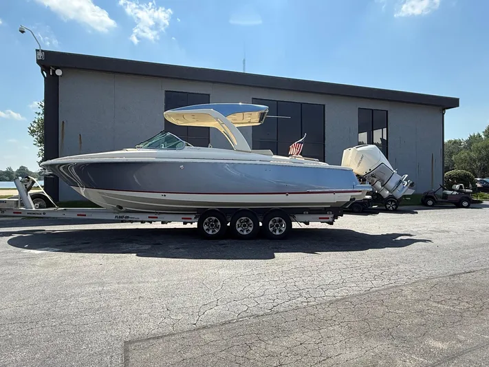 America Yacht Photos Pics 2023 Chris-Craft Launch 31 GT boat on trailer, parked outside a building.