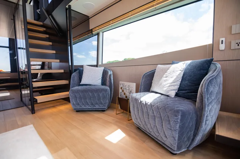  Yacht Photos Pics Luxurious interior of 2022 Bluegame BGX70 yacht with plush seating and modern staircase.
