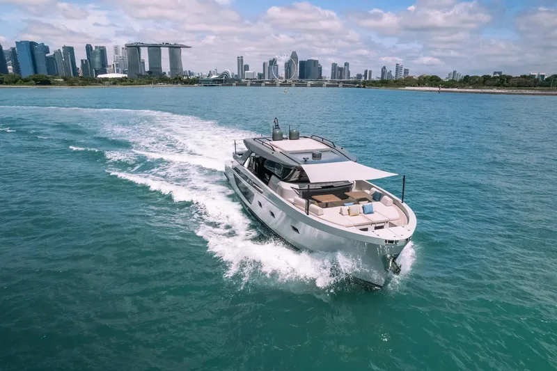  Yacht Photos Pics 2022 Bluegame BGX70 yacht cruising near a city skyline on a sunny day.