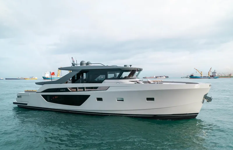  Yacht Photos Pics 2022 Bluegame BGX70 yacht on calm sea with industrial background.