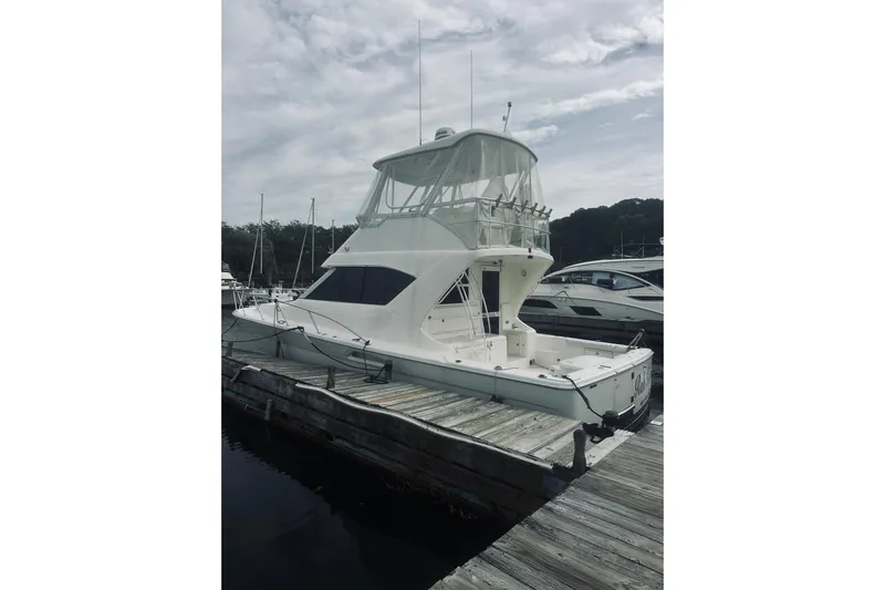 Rah Rah Yacht Photos Pics 2000 Riviera 40 yacht docked at marina under cloudy sky.