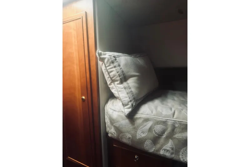 Rah Rah Yacht Photos Pics Interior of 2000 Riviera 40 yacht showing cozy bed and wooden cabinet.