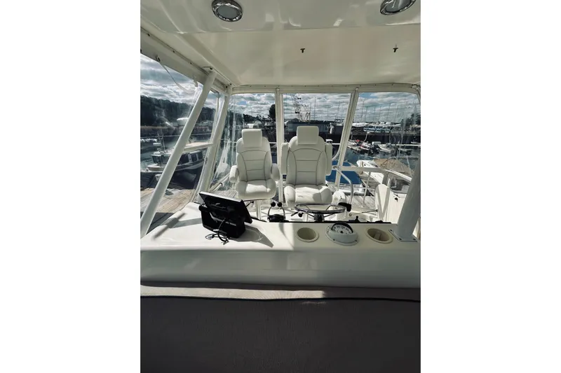 Rah Rah Yacht Photos Pics Interior view of 2000 Riviera 40 yacht helm with white captain chairs and navigation equipment.