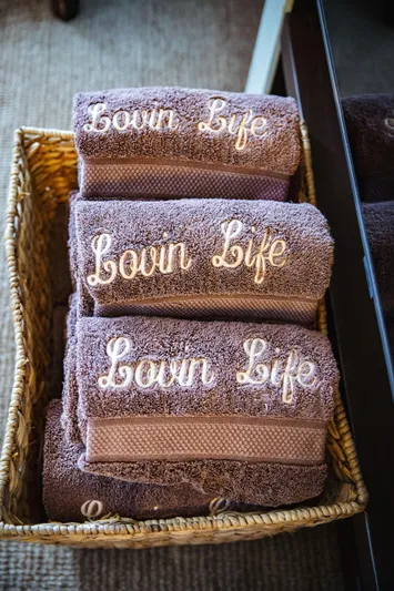 Lovin Life Yacht Photos Pics Basket of brown towels embroidered with "Luvin Life" on a Lazzara LSX 75 yacht.