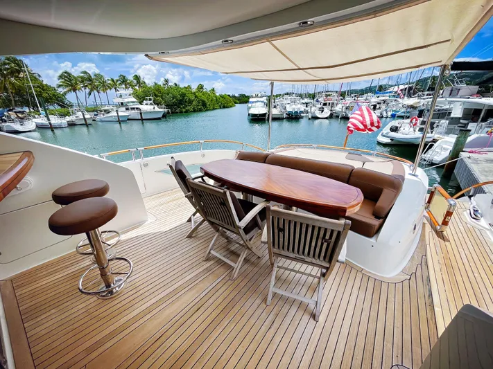 Lovin Life Yacht Photos Pics Luxurious 2008 Lazzara LSX 75 yacht deck with seating, table, and marina view.