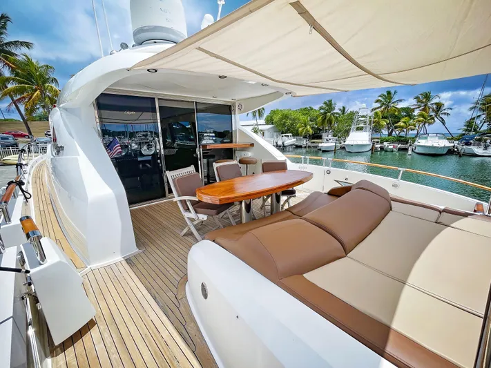 Lovin Life Yacht Photos Pics Luxurious 2008 Lazzara LSX 75 yacht deck with seating and dining area, docked at marina.