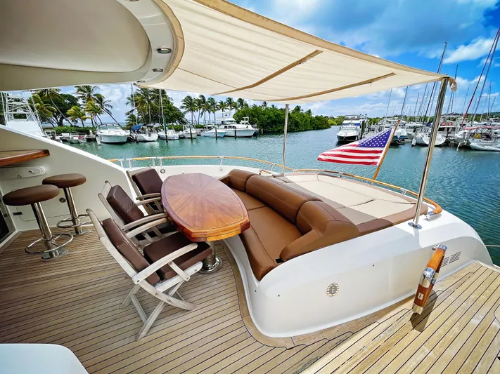 Lovin Life Yacht Photos Pics Luxurious 2008 Lazzara LSX 75 yacht deck with seating, table, and American flag.