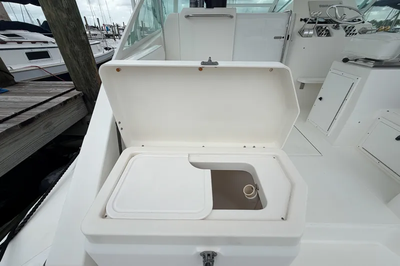 Panacea Yacht Photos Pics Open storage compartment on a 1998 Cabo 31 Express boat docked at a marina.