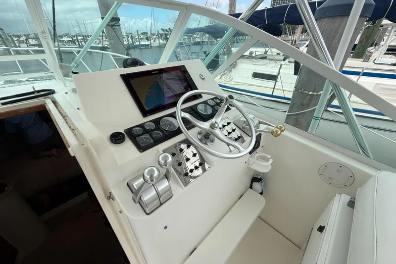 Panacea Yacht Photos Pics Helm of 1998 Cabo 31 Express boat with navigation equipment and steering wheel.