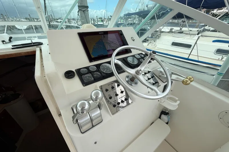 Panacea Yacht Photos Pics 1998 Cabo 31 Express boat helm with navigation controls and steering wheel.
