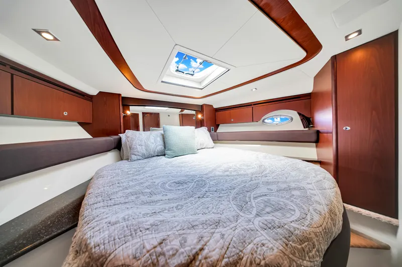  Yacht Photos Pics Luxurious bedroom interior of 2012 Meridian 441 Sedan yacht with skylight and elegant wood finishes.