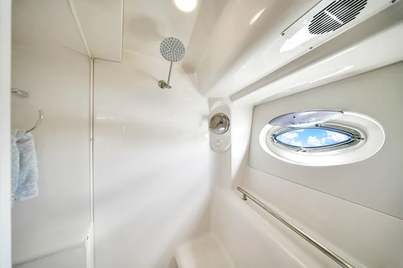  Yacht Photos Pics Luxurious bathroom interior of 2012 Meridian 441 Sedan yacht with porthole and shower.
