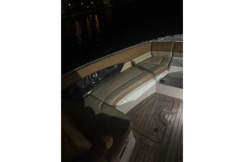  Yacht Photos Pics 2015 Sea Ray 350 SLX boat interior with cushioned seating and wooden flooring at night.