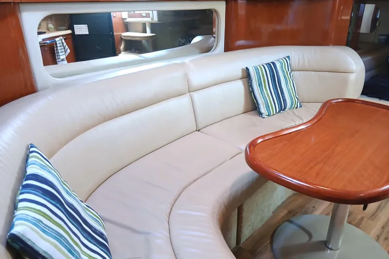Seaswing Yacht Photos Pics Luxurious interior of 2002 Sea Ray 380 Sundancer with curved seating and wooden table.