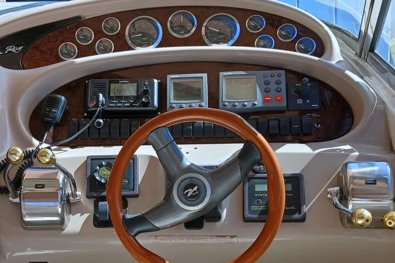 Seaswing Yacht Photos Pics 2002 Sea Ray 380 Sundancer helm with gauges, controls, and wood-trimmed steering wheel.