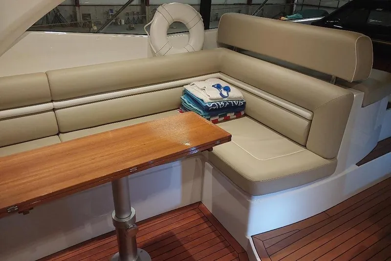 Albacore Yacht Photos Pics Luxurious interior of 2012 Sunseeker Portofino 48 yacht with beige seating and wooden table.