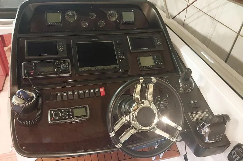 Albacore Yacht Photos Pics Control panel of a 2012 Sunseeker Portofino 48 yacht with steering wheel and navigation instruments.