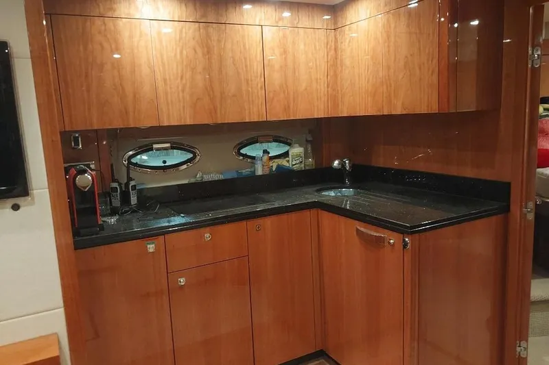 Albacore Yacht Photos Pics Luxurious 2012 Sunseeker Portofino 48 yacht kitchen with sleek wood cabinetry and modern appliances.