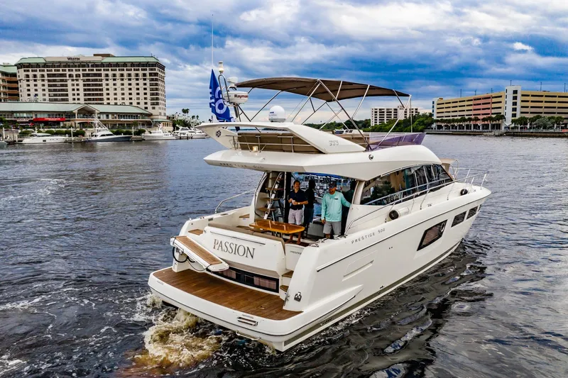  Yacht Photos Pics 2013 Prestige 500 Fly yacht named "Passion" cruising near waterfront buildings.