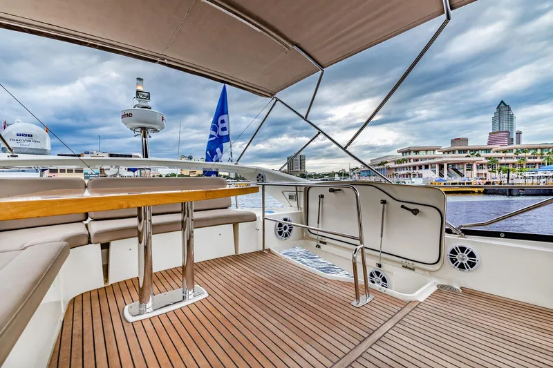  Yacht Photos Pics Luxurious 2013 Prestige 500 Fly yacht deck with cityscape view, featuring elegant seating and wooden flooring.