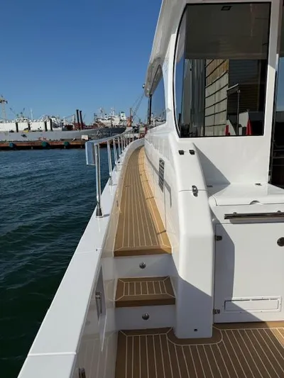 Sea At Last Yacht Photos Pics 2025 Altima Express Coupe yacht deck with wooden flooring, docked at a marina.