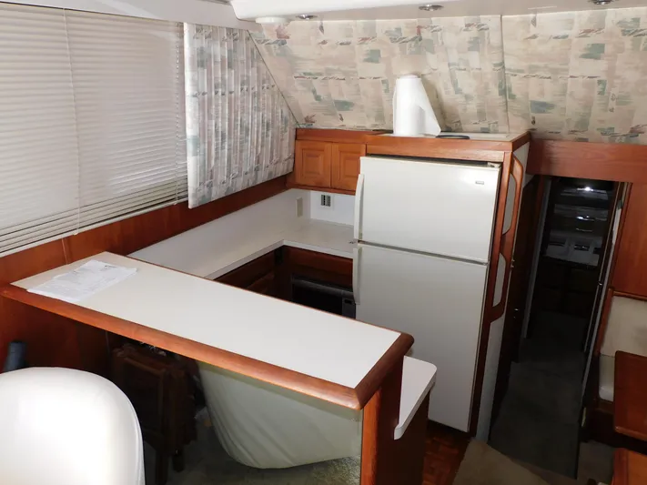 Miss Approach Yacht Photos Pics 1991 Viking 45' Convertible yacht kitchen with white countertops and wood cabinetry.