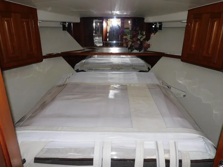 Miss Approach Yacht Photos Pics Interior cabin of 1991 Viking 45' Convertible yacht with wooden cabinets and white bedding.