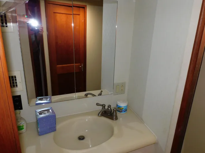Miss Approach Yacht Photos Pics Bathroom sink area in 1991 Viking 45' Convertible yacht with mirror and wooden door.
