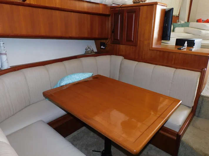 Miss Approach Yacht Photos Pics Cozy dining area in 1991 Viking 45' Convertible yacht with wooden table and cushioned seating.